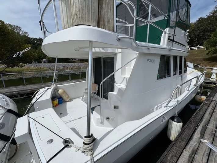 Eirene Yacht Photos Pics 2001 Mainship 390 yacht docked, featuring white exterior and green canopy.