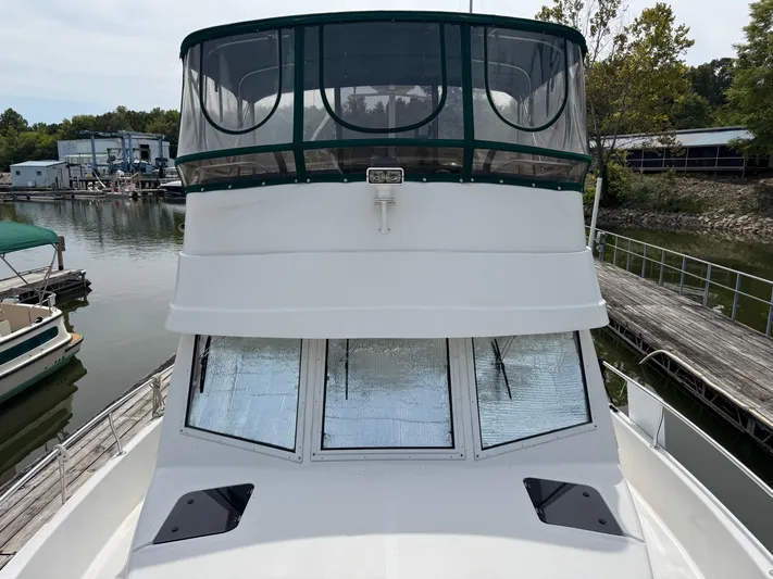 Eirene Yacht Photos Pics 2001 Mainship 390 boat docked at marina, featuring enclosed upper deck and sleek design.