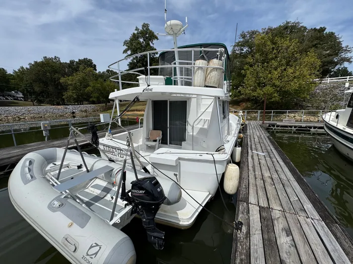 Eirene Yacht Photos Pics 2001 Mainship 390 docked with inflatable boat and Mercury outboard motor.