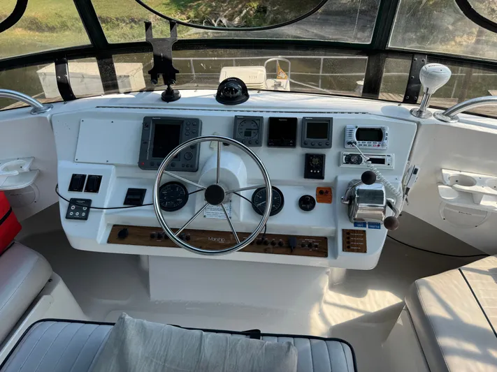 Eirene Yacht Photos Pics Helm of 2001 Mainship 390 boat with steering wheel and navigation instruments.
