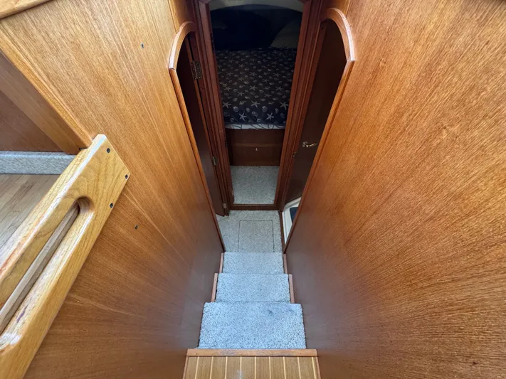Eirene Yacht Photos Pics Interior view of 2001 Mainship 390 yacht, featuring wooden stairs and cozy cabin.