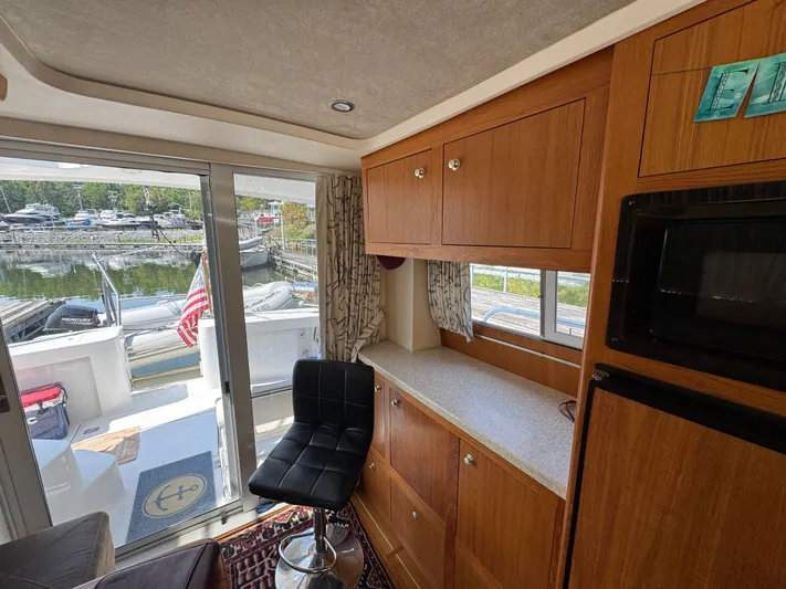 Eirene Yacht Photos Pics Interior of 2001 Mainship 390 yacht with wooden cabinets and marina view.