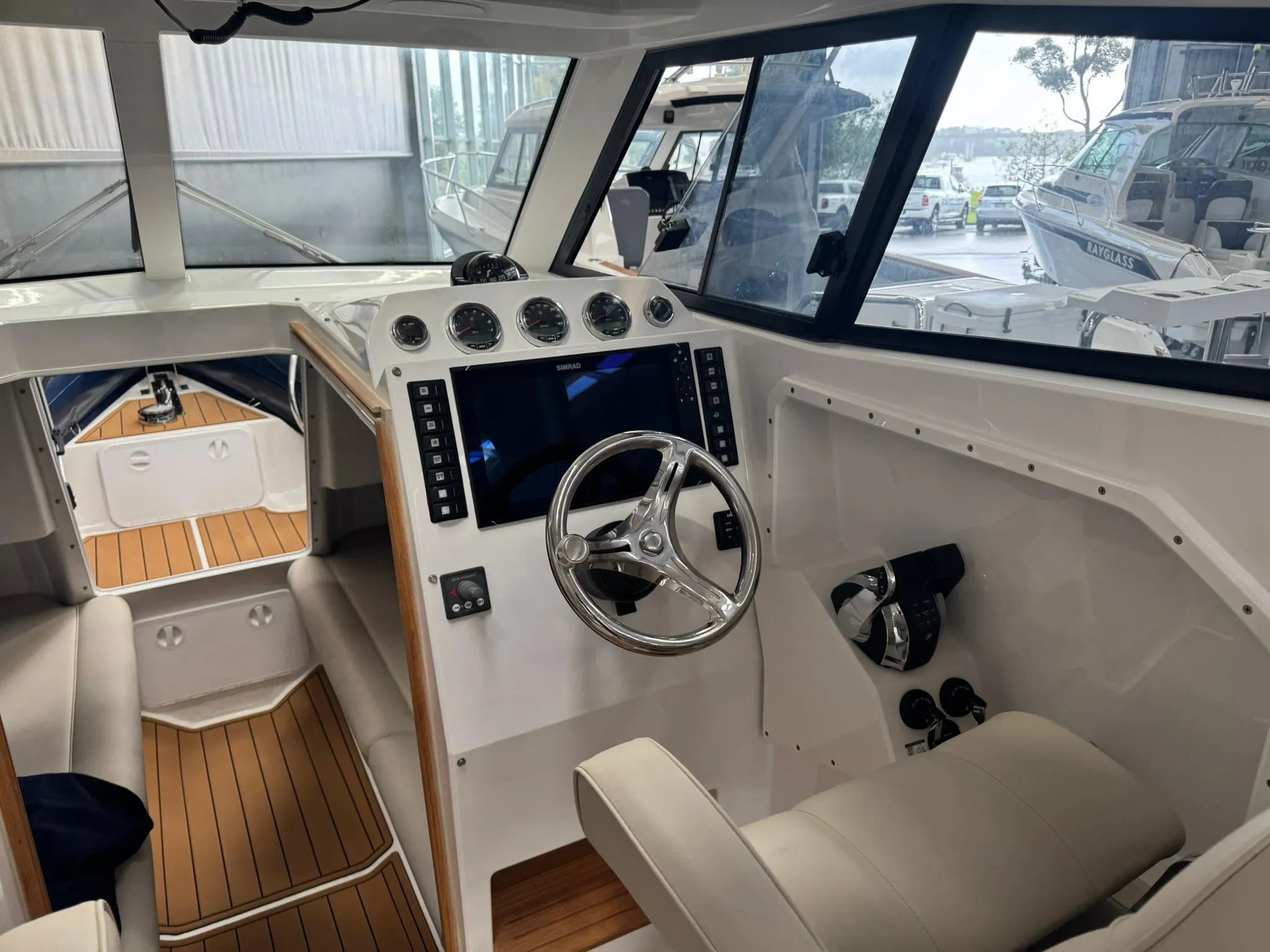Interior of 2025 Protector 310 Targa boat with modern dashboard and steering wheel.