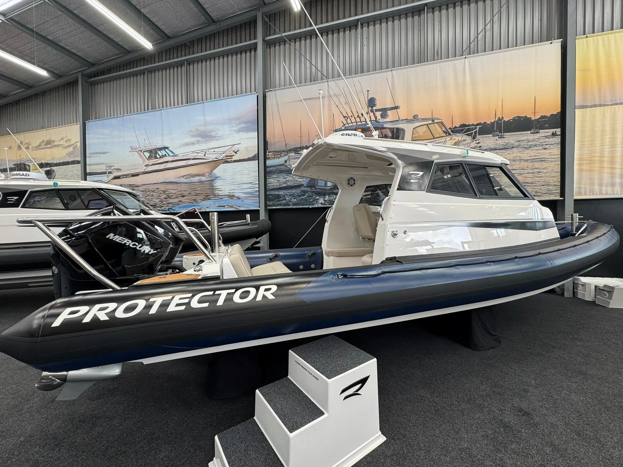 2025 Protector 310 Targa boat with V8 300 HP engine displayed indoors.