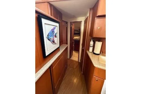  Yacht Photos Pics 2006 Silverton 42 Convertible yacht interior with wood cabinetry and colorful fish artwork.