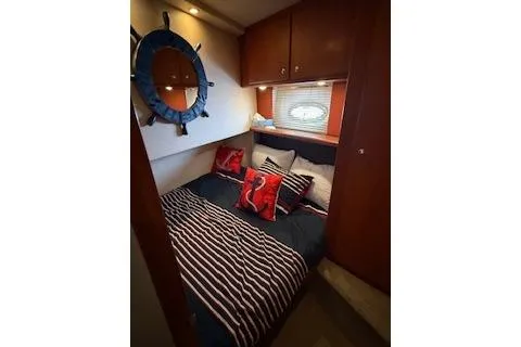  Yacht Photos Pics 2006 Silverton 42 Convertible yacht bedroom with nautical decor and striped bedding.