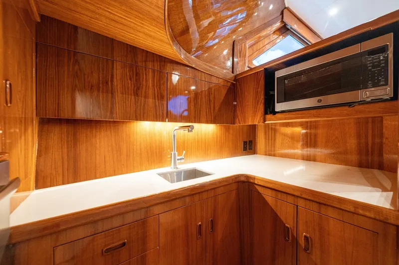 Annie Girl Yacht Photos Pics Luxurious wooden yacht kitchen with modern appliances, featuring a sleek sink and microwave.