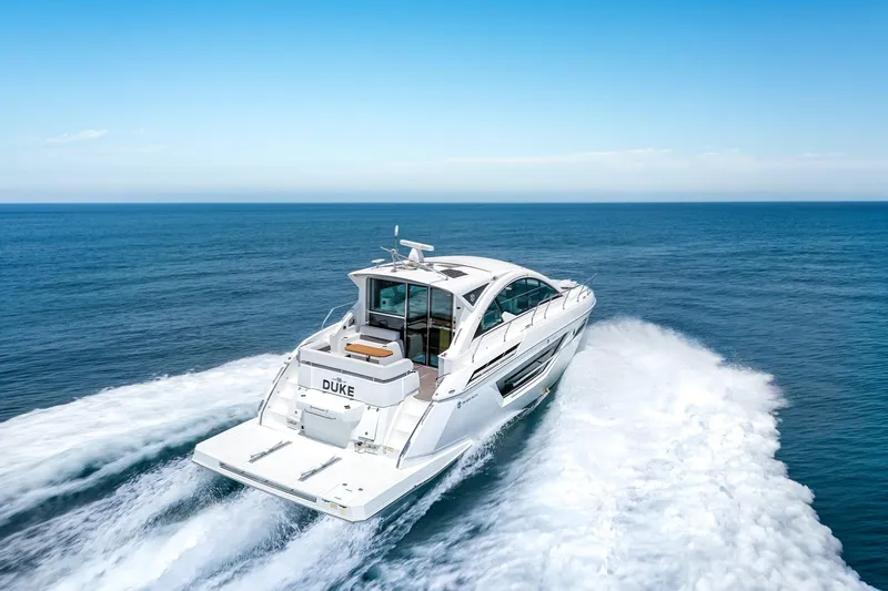 Duke Yacht Photos Pics 2018 Cruisers Yachts 50 Cantius cruising on open sea, rear view.