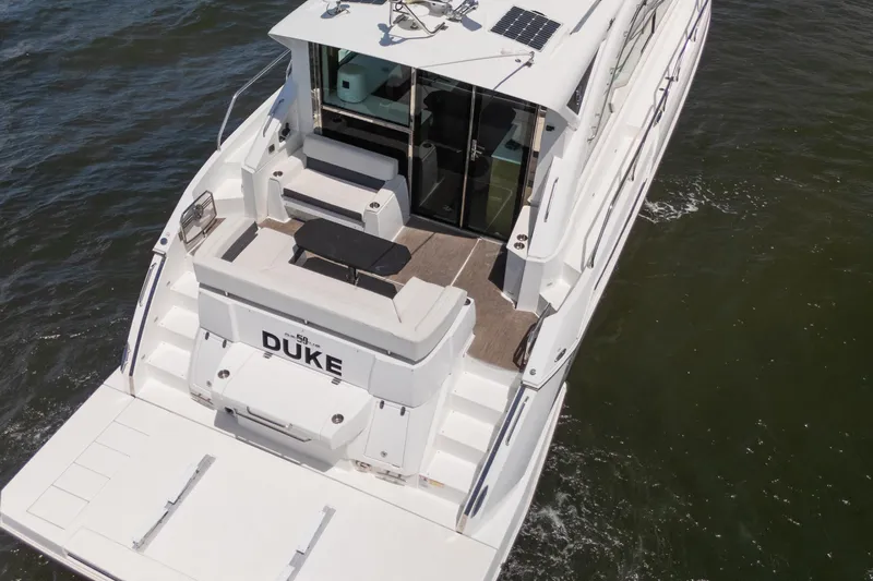 Duke Yacht Photos Pics 2018 Cruisers Yachts 50 Cantius on water, featuring spacious deck and seating area.
