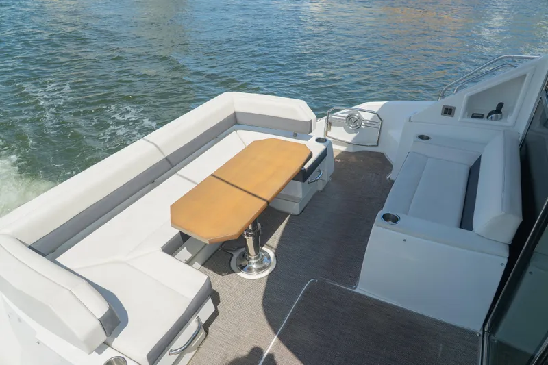 Duke Yacht Photos Pics 2018 Cruisers Yachts 50 Cantius deck with seating and table, overlooking water.