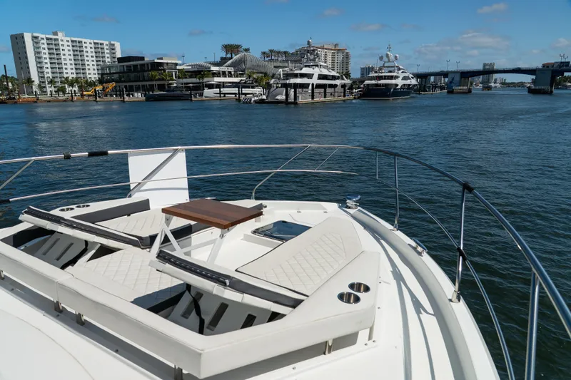 Duke Yacht Photos Pics 2018 Cruisers Yachts 50 Cantius on water, featuring luxurious deck seating and cityscape backdrop.
