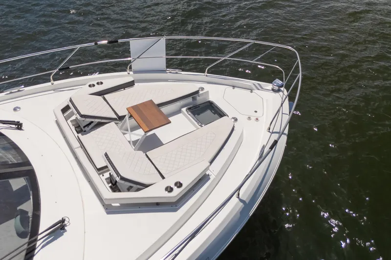 Duke Yacht Photos Pics 2018 Cruisers Yachts 50 Cantius bow with sun loungers and table on calm water.