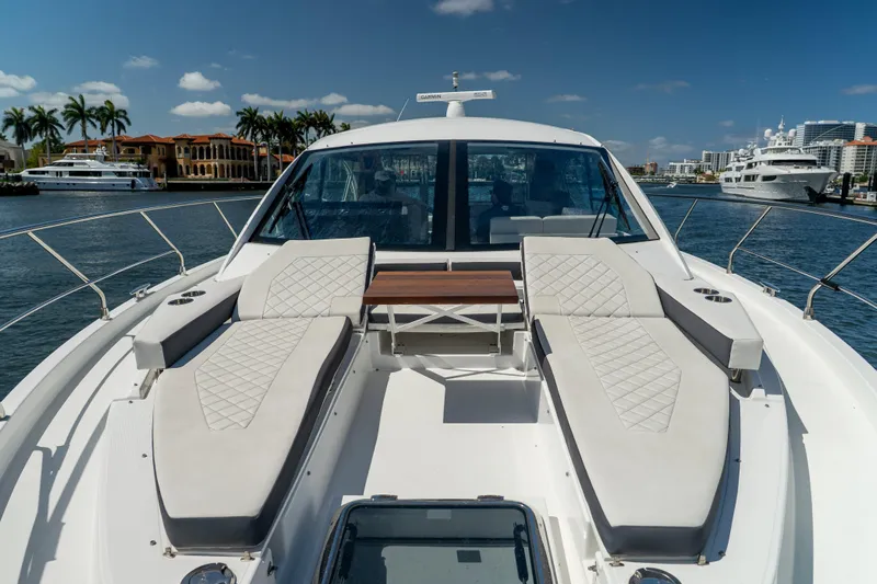 Duke Yacht Photos Pics 2018 Cruisers Yachts 50 Cantius with luxurious deck seating, docked in a scenic marina.