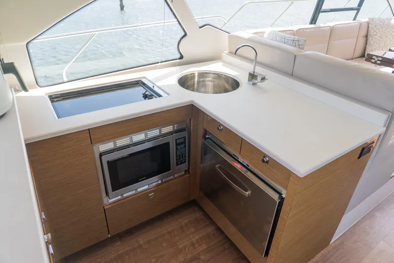 Duke Yacht Photos Pics Modern kitchen area on 2018 Cruisers Yachts 50 Cantius with sink, stove, and microwave.