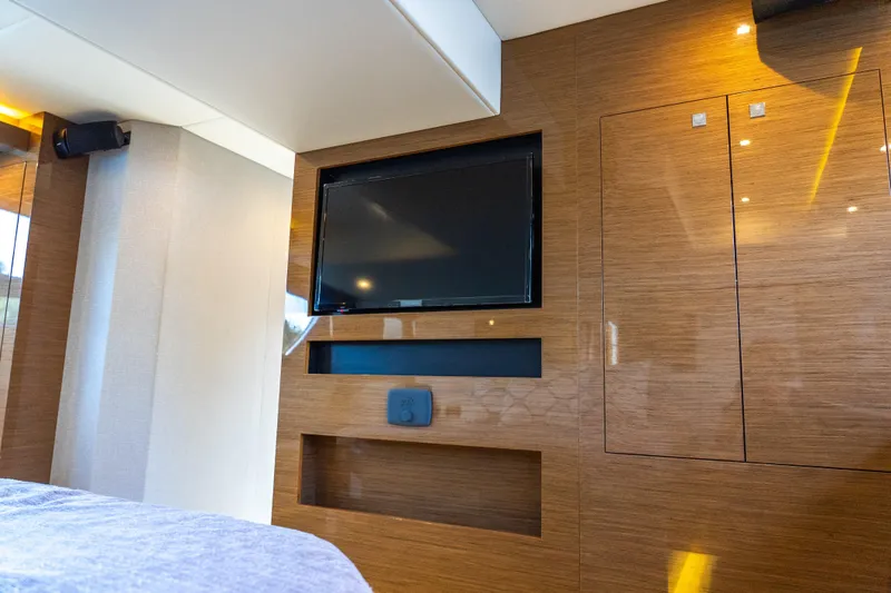 Duke Yacht Photos Pics Luxurious interior of 2018 Cruisers Yachts 50 Cantius with mounted TV and wood paneling.