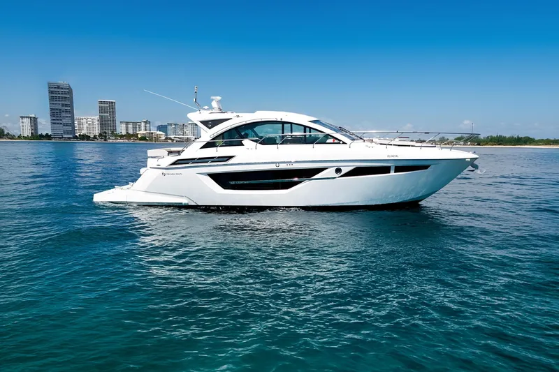 Duke Yacht Photos Pics 2018 Cruisers Yachts 50 Cantius on calm water with city skyline backdrop.