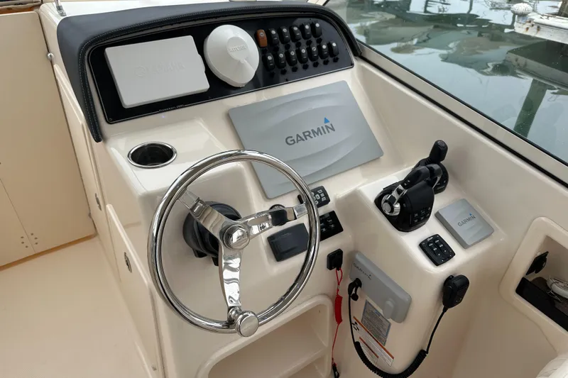  Yacht Photos Pics 2018 Grady-White Freedom 285 boat dashboard with Garmin navigation system and steering wheel.