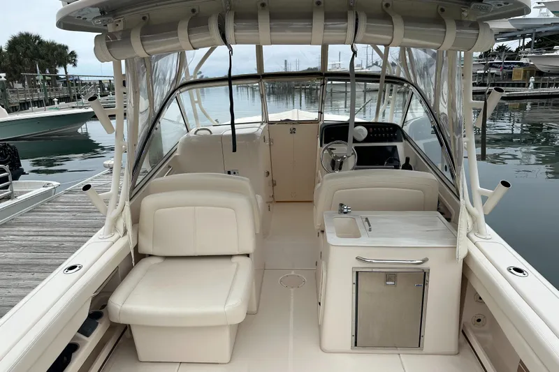  Yacht Photos Pics 2018 Grady-White Freedom 285 boat interior with seating and helm at marina.