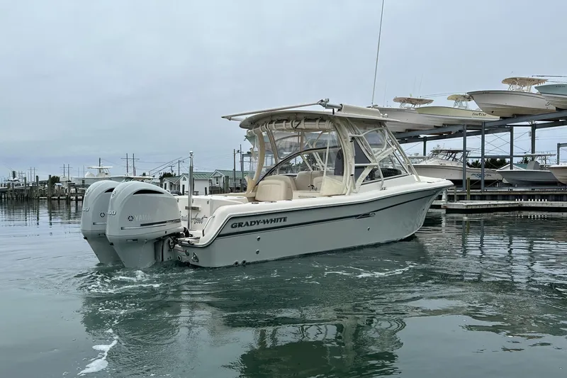  Yacht Photos Pics 2018 Grady-White Freedom 285 boat on calm water near a marina.