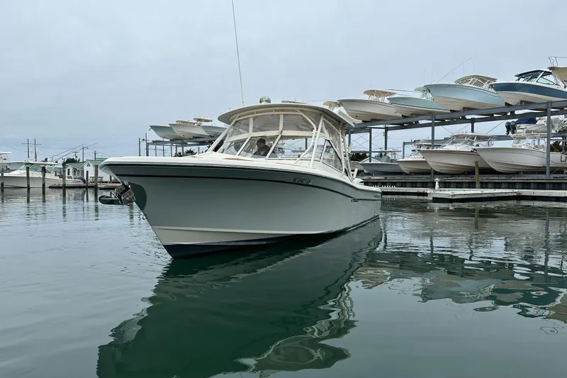  Yacht Photos Pics 2018 Grady-White Freedom 285 boat docked in marina, surrounded by other vessels.