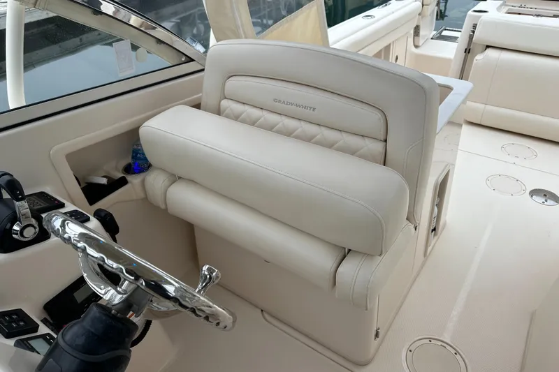  Yacht Photos Pics 2018 Grady-White Freedom 285 boat interior with beige seating and steering wheel.