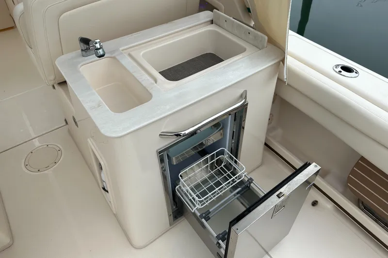  Yacht Photos Pics 2018 Grady-White Freedom 285 boat interior with sink and open storage compartment.