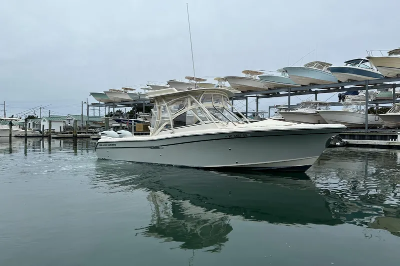  Yacht Photos Pics 2018 Grady-White Freedom 285 boat docked in a marina, surrounded by calm waters.