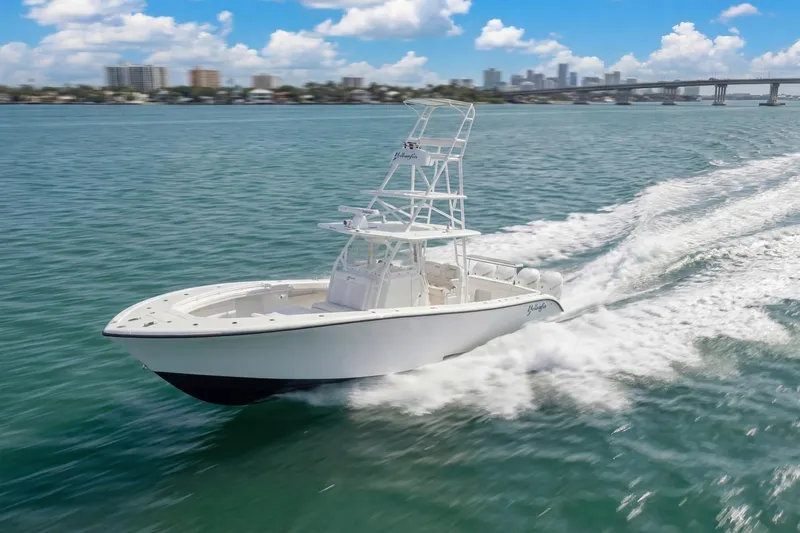  Yacht Photos Pics 2015 Yellowfin 39 Offshore boat cruising on open water with city skyline in background.
