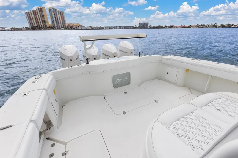  Yacht Photos Pics 2015 Yellowfin 39 Offshore boat with Mercury engines on calm water, cityscape background.