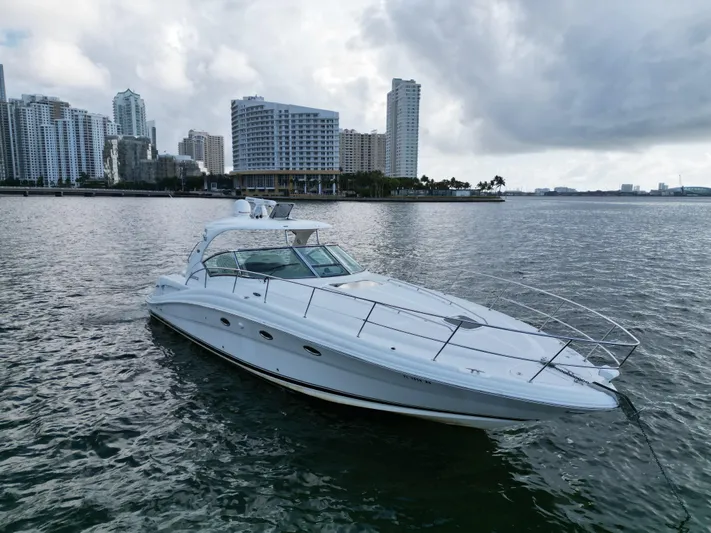  Yacht Photos Pics 2005 Sea Ray 44 Sundancer yacht on water with city skyline in background.