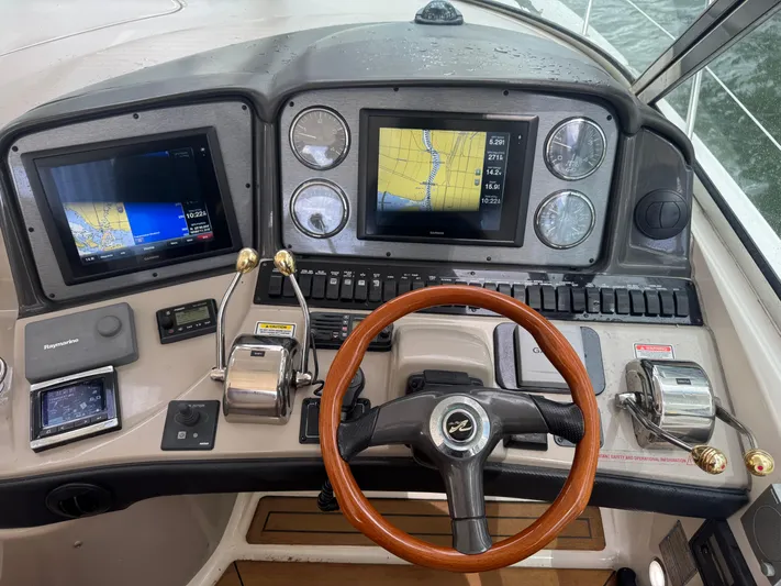  Yacht Photos Pics 2005 Sea Ray 44 Sundancer helm with navigation screens and wooden steering wheel.