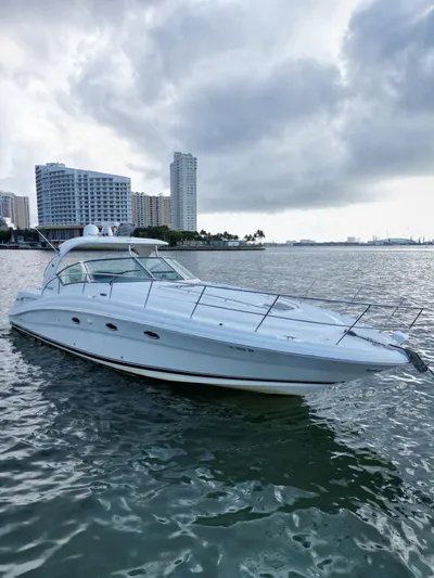  Yacht Photos Pics 2005 Sea Ray 44 Sundancer yacht on water with city skyline background.