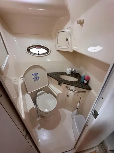  Yacht Photos Pics 2005 Sea Ray 44 Sundancer bathroom with toilet, sink, and porthole window.