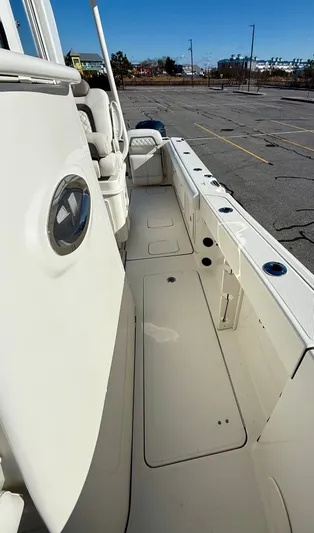 Reelaxing Yacht Photos Pics 2017 World Cat 295 CC boat interior, featuring spacious deck and seating in a parking lot setting.
