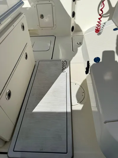 Reelaxing Yacht Photos Pics Interior of 2017 World Cat 295 CC boat, featuring storage compartments and seating area.