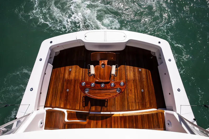 On The Edge III Yacht Photos Pics 2019 Viking 62 Convertible yacht with polished wooden deck and fishing chair.