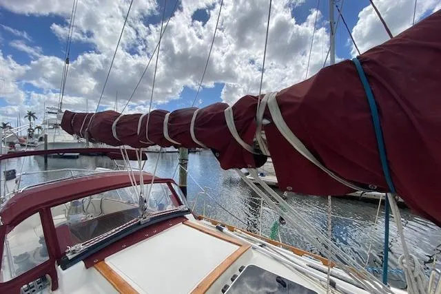 Irish Rose Yacht Photos Pics Sailboat Pacific Seacraft Crealock 34, 1995 model, docked with sails wrapped, under a cloudy sky.