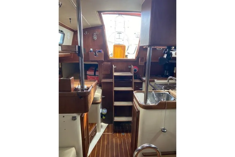 Irish Rose Yacht Photos Pics Interior of 1995 Pacific Seacraft Crealock 34 sailboat, featuring wooden cabinetry and compact kitchen.