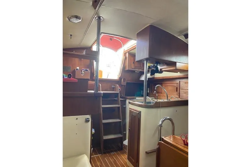 Irish Rose Yacht Photos Pics Interior of 1995 Pacific Seacraft Crealock 34 sailboat, featuring wooden cabinetry and compact kitchen.