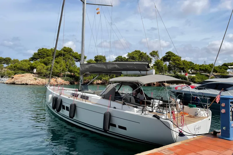  Yacht Photos Pics 2013 Hanse 575 yacht docked in a scenic marina with lush greenery.