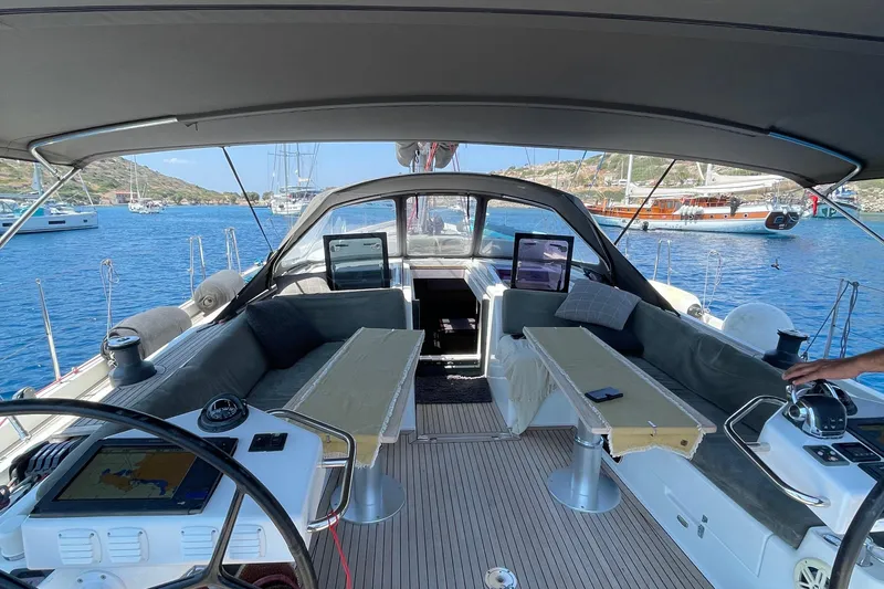  Yacht Photos Pics Luxurious 2013 Hanse 575 yacht cockpit with modern navigation equipment, anchored in a scenic bay.