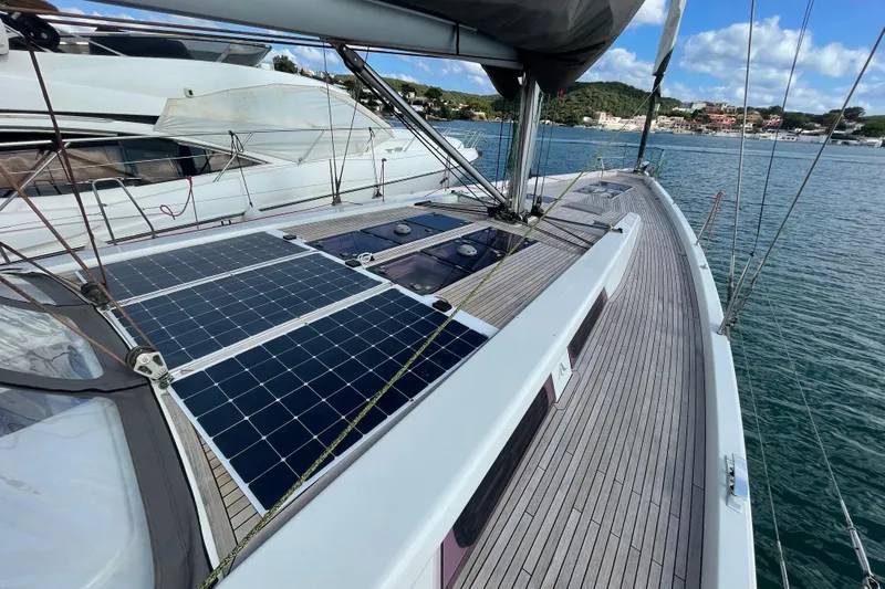  Yacht Photos Pics 2013 Hanse 575 yacht with solar panels on deck, docked in a scenic harbor.