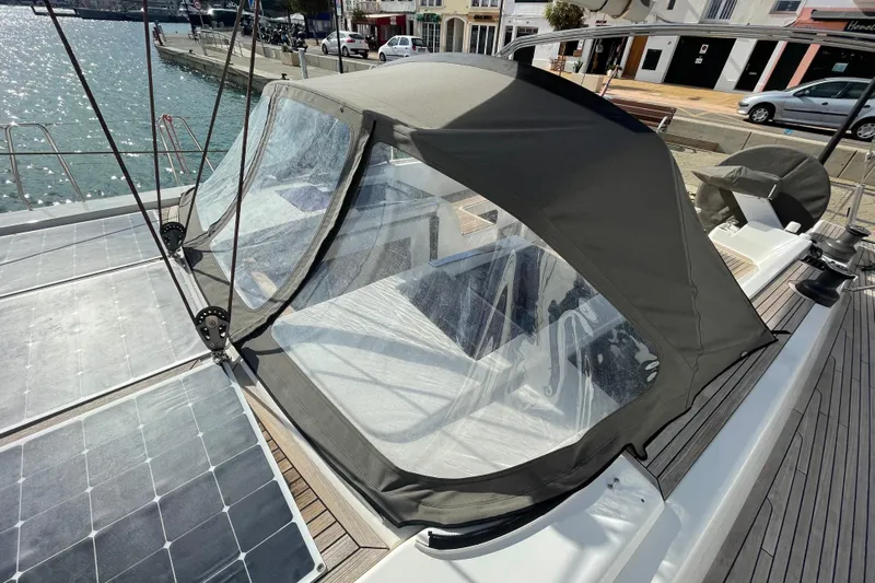  Yacht Photos Pics 2013 Hanse 575 yacht with cockpit cover and solar panels, docked by the water.