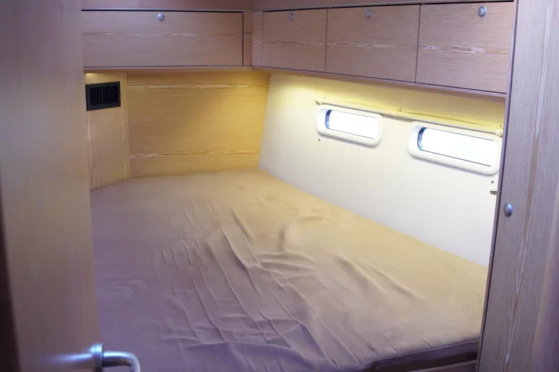  Yacht Photos Pics Cozy cabin interior of 2013 Hanse 575 yacht with wooden finish and porthole windows.