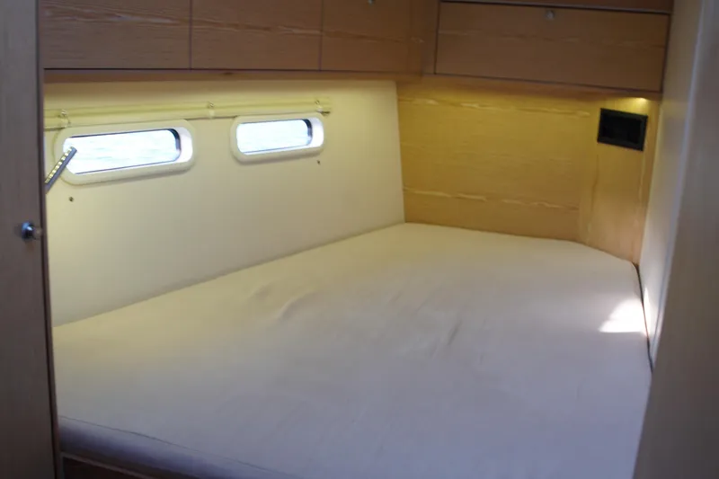  Yacht Photos Pics Cozy cabin interior of 2013 Hanse 575 yacht with natural light and wooden finish.