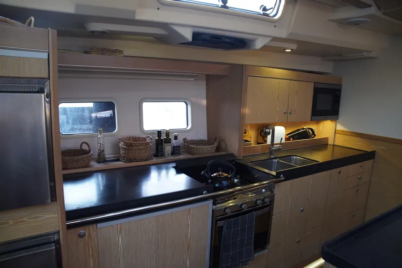  Yacht Photos Pics Modern kitchen interior of 2013 Hanse 575 yacht with sleek countertops and wooden cabinetry.
