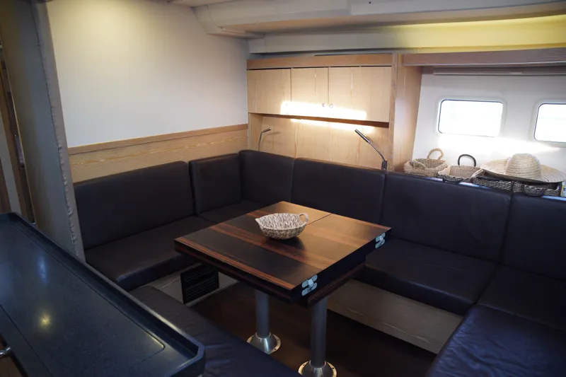  Yacht Photos Pics Interior of 2013 Hanse 575 yacht with cozy seating and wooden table.