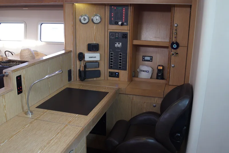  Yacht Photos Pics Navigation station in 2013 Hanse 575 yacht with control panel and seating.