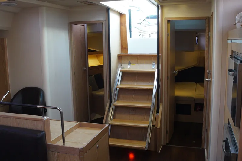  Yacht Photos Pics Interior of 2013 Hanse 575 yacht featuring wooden stairs, seating, and cabin access.