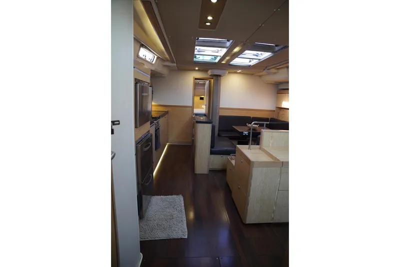  Yacht Photos Pics Interior of 2013 Hanse 575 yacht, featuring modern kitchen and dining area with skylights.